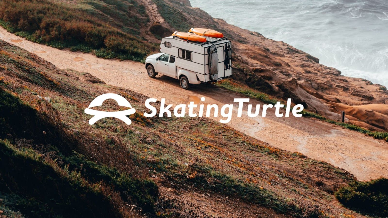 A camper truck parked on a scenic cliffside road overlooking the ocean, with the Skating Turtle logo and name prominently displayed in white, symbolizing adventure and outdoor exploration.